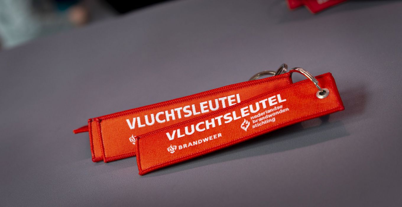 Foto van rode sleutelhangers met daarop de tekst vluchtsleutel