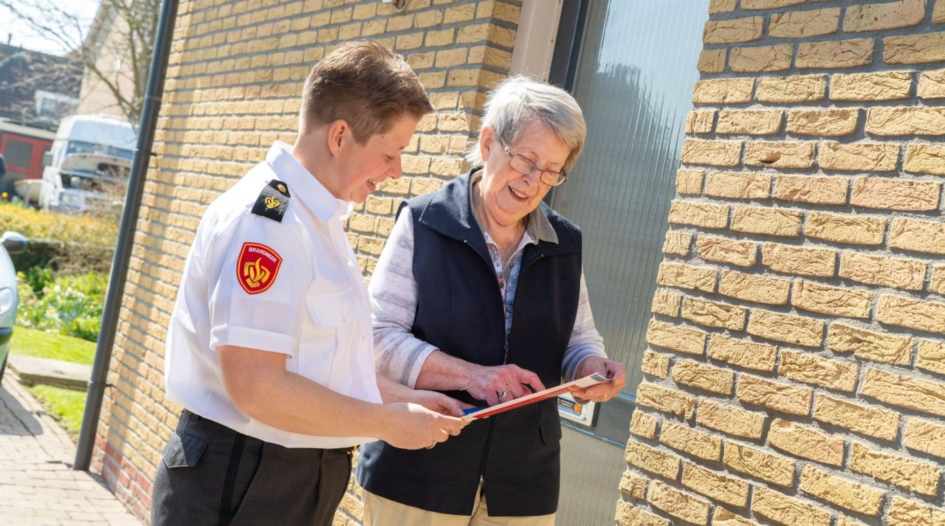 Brandweervrouw bekijkt samen met bewoner de woningchecklist